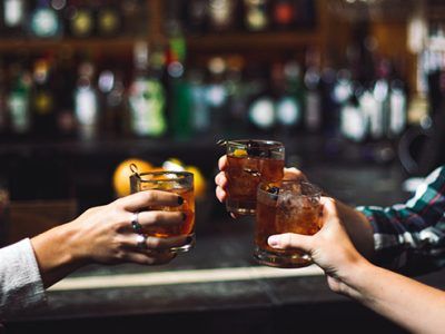 glasses toasting at a bar