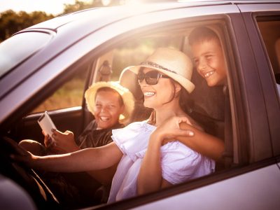 Mom and two kids in a car going on a road trip